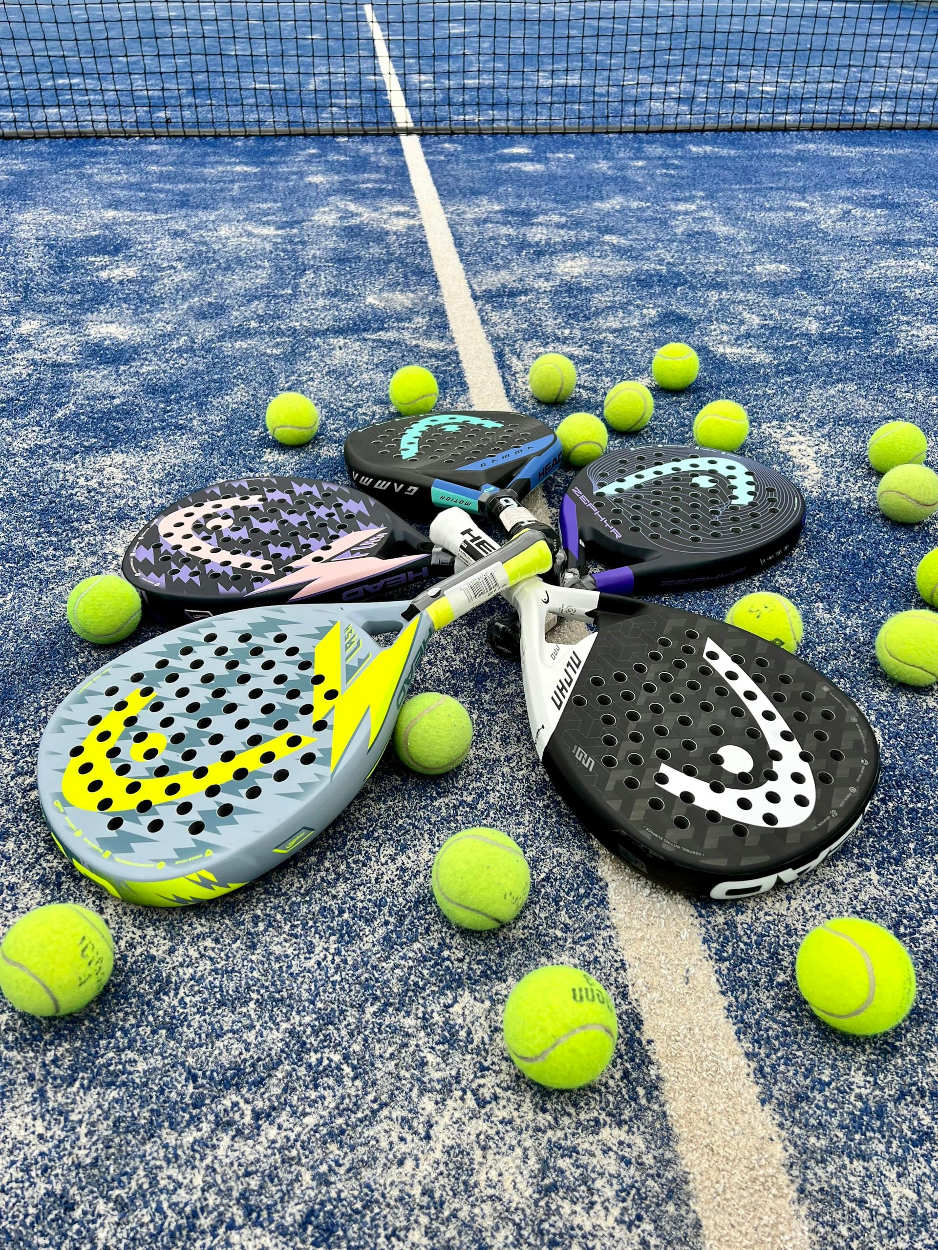 Raquettes et balles de padel posées sur le terrain