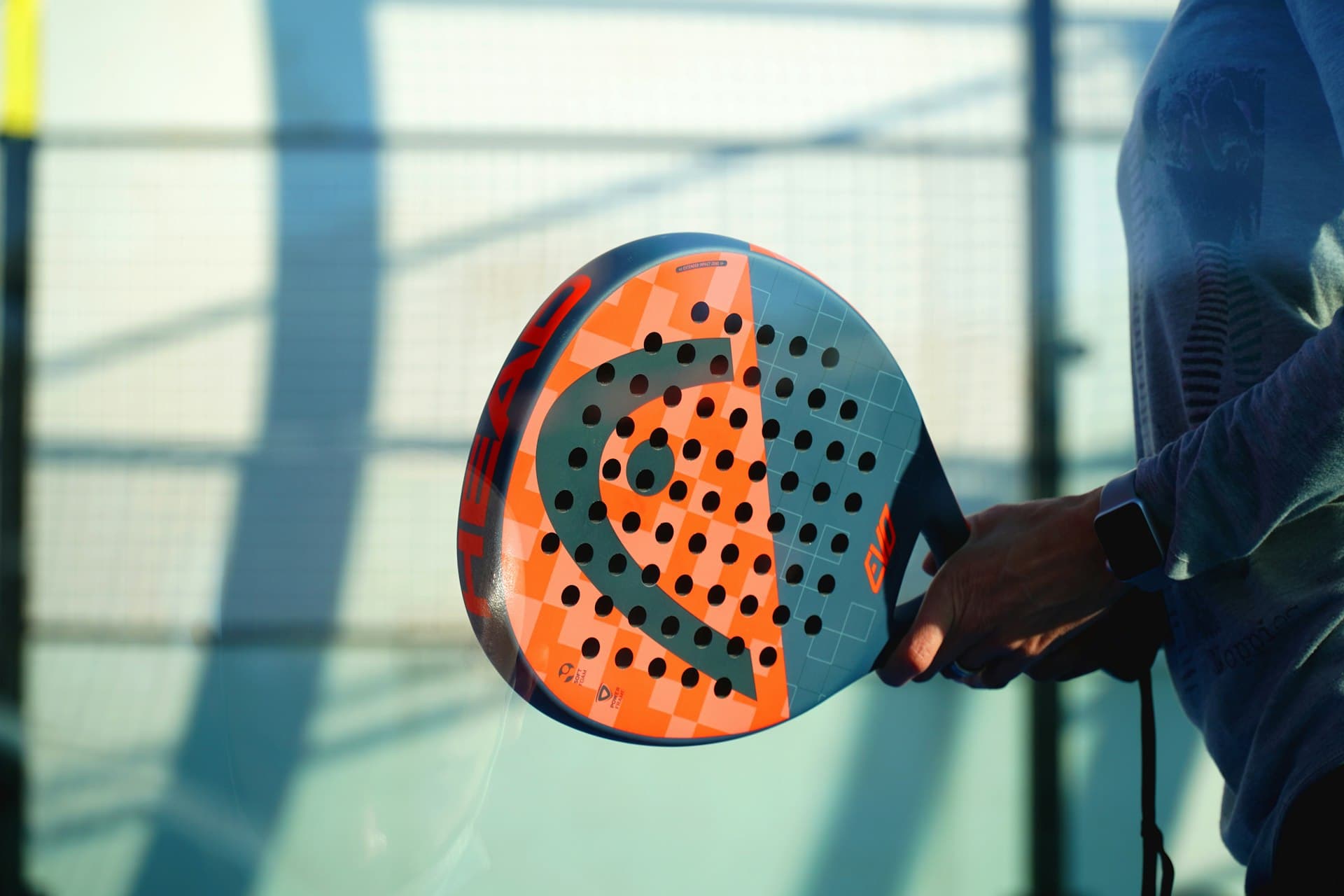 Gros plan sur une raquette de padel orange