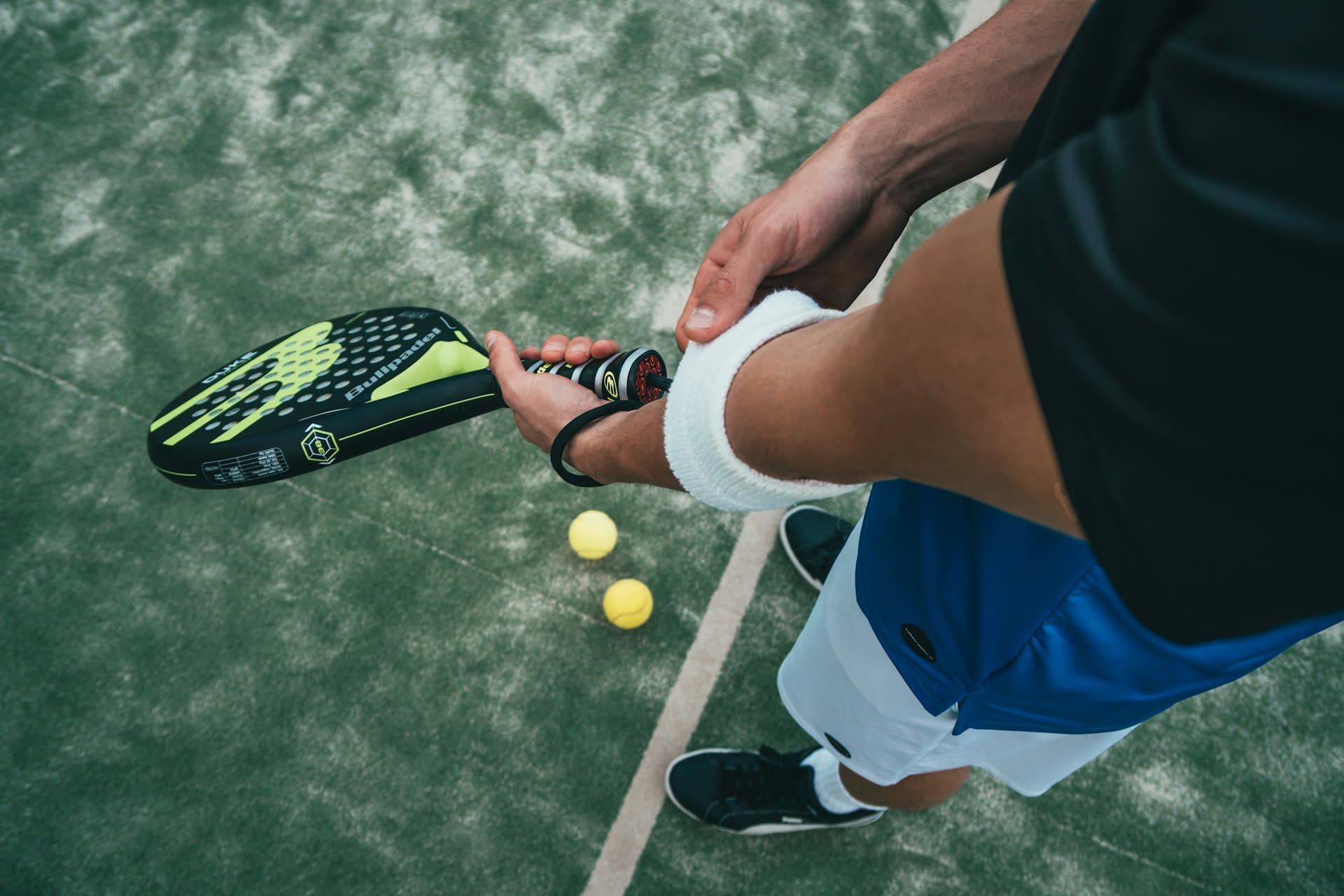 Joueur au service sur un terrain de padel